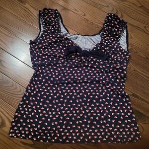 Colorful sleeveless top with bow at neck line.